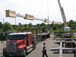 Crane lifting crated shaft